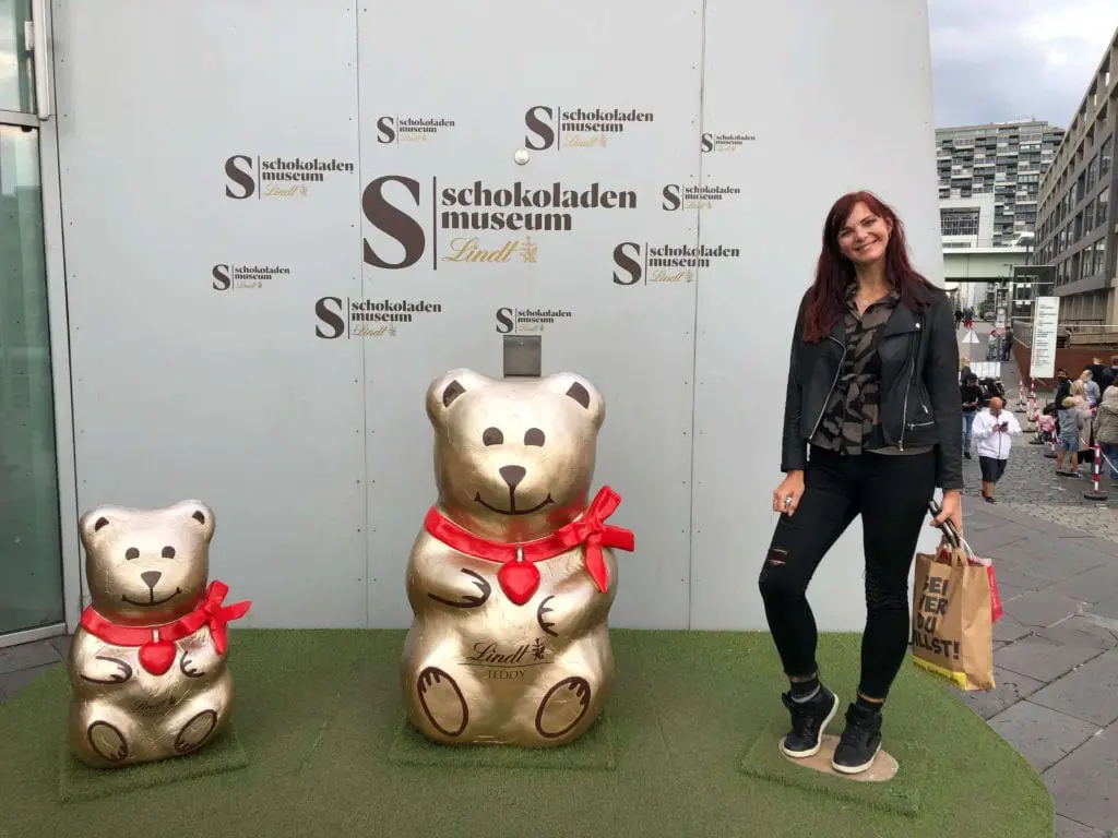 Things to do in Cologne Old Town - girl stood next to statues of the lindt bears outside the chocolate museum